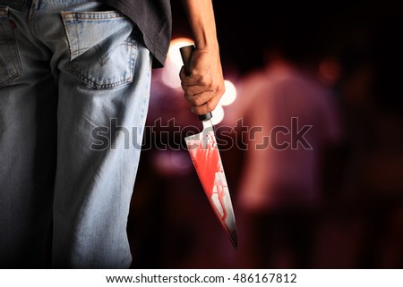 Evil criminal with large sharp knife ready for robbery or to commit a homicide