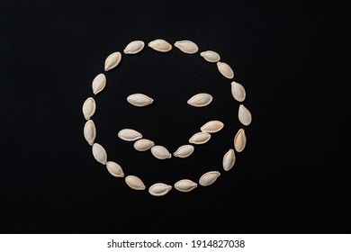 An Evil Face Lined With White Seeds On A Black Background.