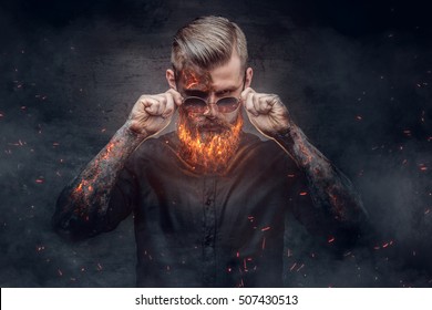 An evil man with burning beard in fire sparks and smoke. Halloween 31 October. - Powered by Shutterstock