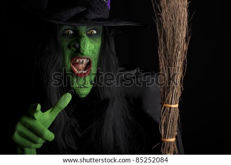 Evil witch and her broomstick, black background