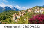 Evisa, Corsica, a picturesque hillside village with red-roofed houses, vibrant flowers, and stunning mountain views.