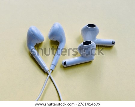 evolution of audio technology, white wired and wireless earbuds isolated on yellow