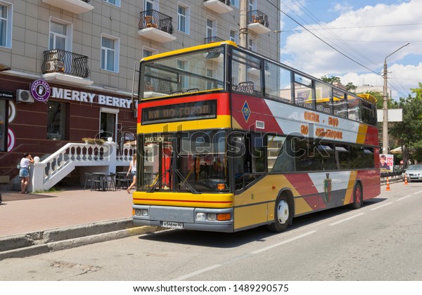 Evpatoria, Saki region,\
Crimea, Russia - July 20, 2019: City-tour cabriolet tour bus in\
Evpatoria near the cafe Merry Berry on Frunze street in the city of\
Evpatoria, Crimea