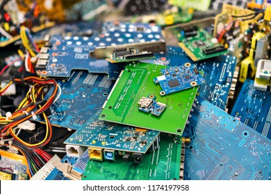 E-waste heap from discarded laptop parts. Connectors, PCB, notebook cards. Colorful blurry background from PC components. Idea of electronics industry, eco, sorting and disposal of electronic waste.