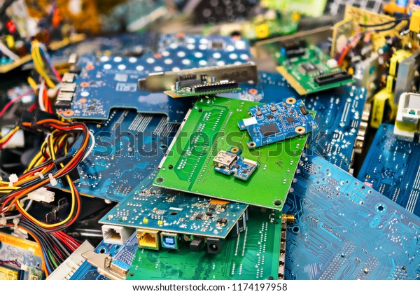 E-waste heap from discarded laptop parts.\
Connectors, PCB, notebook cards. Colorful blurry background from PC\
components. Idea of electronics industry, eco, sorting and disposal\
of electronic waste.