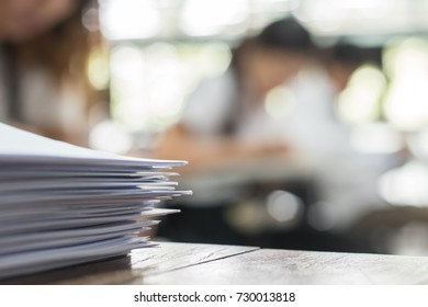 Exam answer sheet or application paper blurry view on table in examination room with blur education background of school university students taking exam test writing answer in seat row with stress