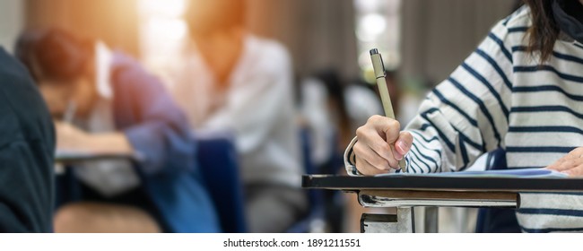 Exam At School With Student's Taking Educational Admission Test In Class, Thinking Hard, Writing Answer In University Classroom, Education And World Literacy Day Concept