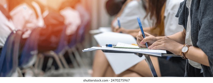 Exam at school with student's taking educational admission test in class, thinking hard, writing answer in university classroom, education and world literacy day concept - Powered by Shutterstock