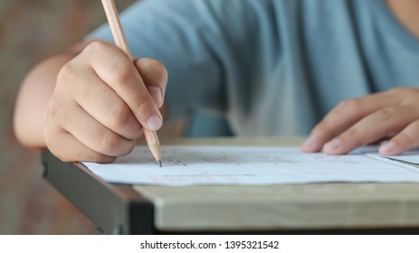 Exam Test School Or University Concept : Hand Student Holding Pencil Writing Standardized Answer Multiple Carbon Paper Form With Gray Black Answers Sheet Bubbled Doing Final Assessment In Classroom