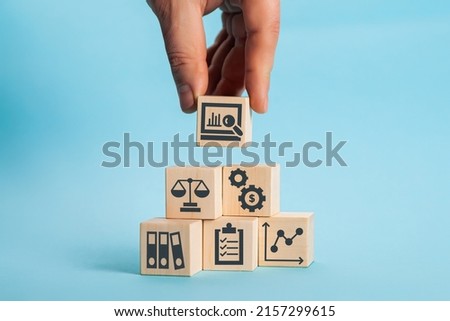 Examination and evaluation of the financial statements of an organization income statement, balance sheet, cash flow statement. Audit business concept. Holding wooden cubes with audit icon.