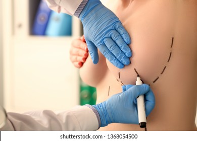 Examination of female breast by mammologist in blue protective gloves in hospital office background. Preparation surgery method markup cut correction form health care insurance people concept.