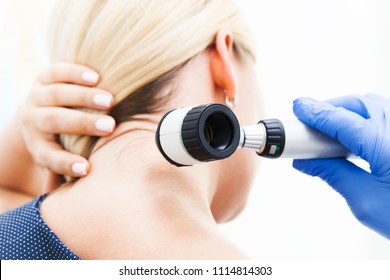 Examination of the patient's skin by a dermatologist using a dermatoscope