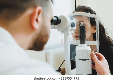 Examination of vision on modern ophthalmological equipment. Eye examination of a woman at an ophthalmologist's appointment using microscopes. Vision treatment at an ophthalmologist appointment - Powered by Shutterstock