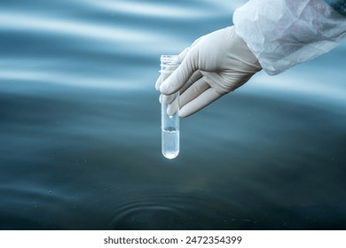 examination of water quality in a natural reservoir. a test tube in a man's hand with water to check its purity. - Powered by Shutterstock