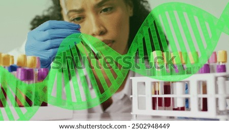 Examining test tube, scientist with DNA strand image over laboratory scene. research, biotechnology, genetics, innovation, analysis, experiment