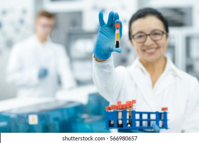 Examining Your Blood. Senior Female Scientist Holding Out Blood Test Tube To The Camera Smiling Cheerfully Copyspace Blood Testing Health Clinician Biologist Immunology Chemistry Selective Focus