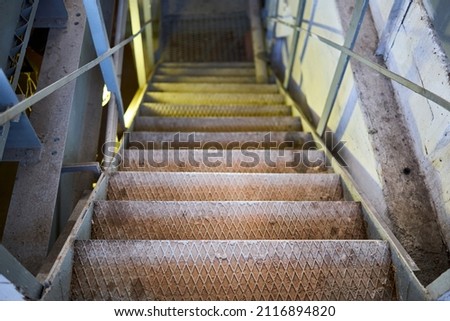 Example of chemical plant steampunk retro style interior part with copyspace. Abstract image of industrial textured rusted stairs going down vertical or downstairs.