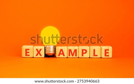 Example examples symbol. Concept word Example on beautiful wooden blocks. Beautiful orange background. Beautiful yellow light bulb. Business example examples concept. Copy space.