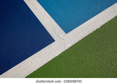 Example image of a newly surfaced, empty pickleball court with multi-color surface and white lines.

