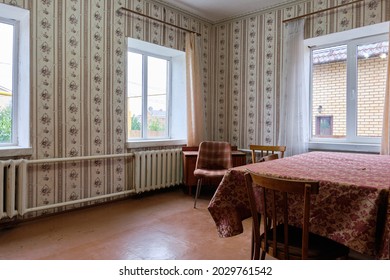 Example Of Old Soviet Russian Poor Interior In Khruschev House. Aged Table. Shabby Floor. Tattered Wallpaper On The Wall. Apartment Of Pensioners.