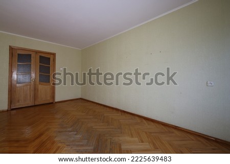Example of Old Soviet Russian poor interior in Leningrad project House. Aged  parquet and doors. Shabby floor. Tattered wallpaper on the wall. Apartment of pensioners. Selective focus.