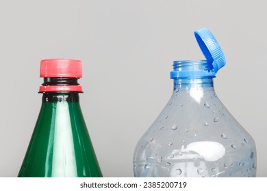 Example of older model and new cap attached to plastic bottle, connected to the neck of the bottle by solid tab attached to safety ring. 
