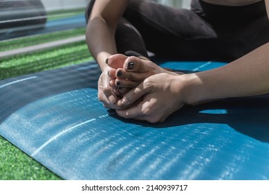 Example Of A Seated Inner Thigh Stretch. Anonymous Shot Focused On The Toes. Stretching On A Blue Yoga Mat.