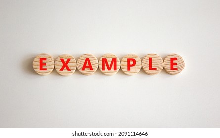 Example Symbol. The Concept Word Example On Wooden Circles. Beautiful White Background, Copy Space. Business And Example Concept.