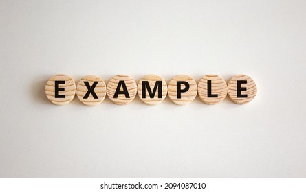 Example Symbol. The Concept Word Example On Wooden Circles. Beautiful White Background, Copy Space. Business And Example Concept.