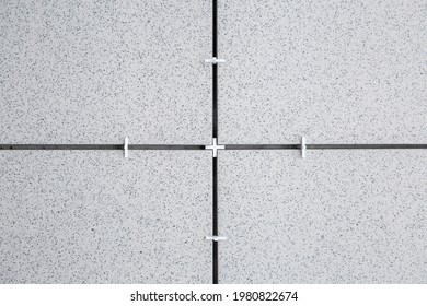 An example of using crosses (spacers)  for tiles during tiling works. Finishing and renovation works. Close up image with copy space