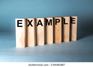 EXAMPLE Word Written On Wooden Blocks On Blue Grey Background