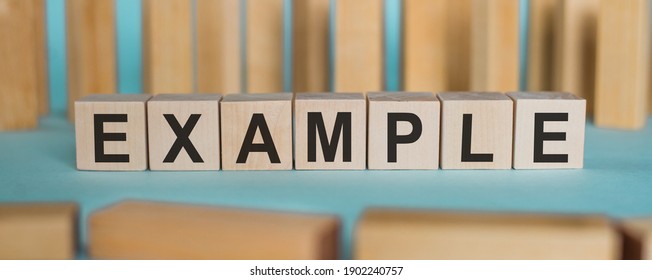 EXAMPLE Word Written On Wooden Blocks On Light Blue Background.