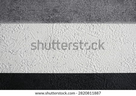 Examples of decorative wall textures (stucco) in three color variations, gray, white, and black. Textured finishes like this are typically used to add aesthetic dimension to building exteriors or interior walls.