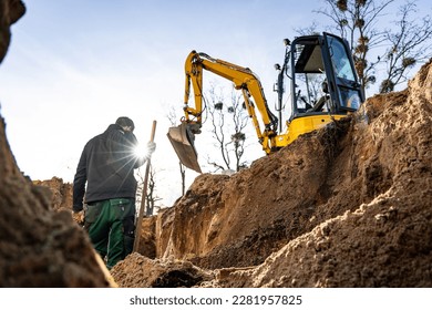 Excavation and earthwork at a construction site with a person and excavator