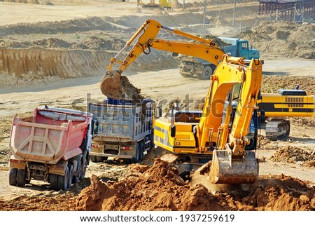 Excavation and loading onto dump trucks with excavators. The work of construction equipment in the production of earthworks
