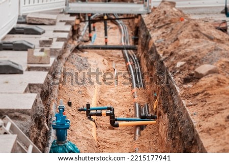 Excavation trench on a city street to replace plastic water pipes or laying cables. Repair and renovation at construction and development site.