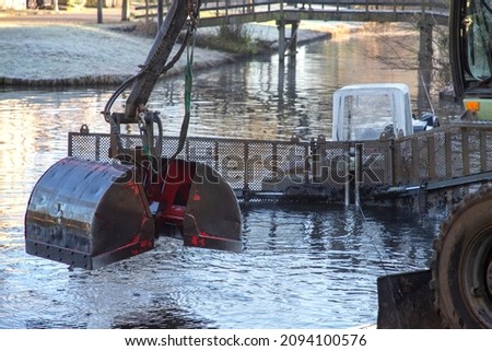 excavator bagger in water digging for mud
