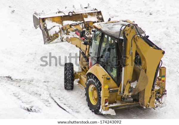 An excavator cleans\
snow blocked parking