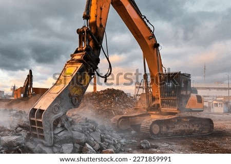 Excavator with concrete crusher at demolition site