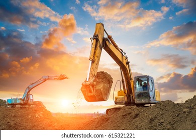 excavator in construction site on sunset sky background - Shutterstock ID 615321221