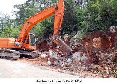 excavator crusher machine breaks rocks to widen road