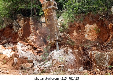 excavator crusher machine breaks rocks to widen road