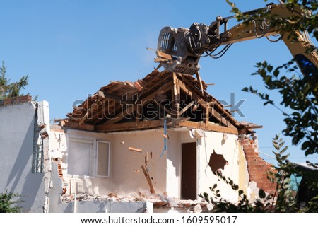 excavator in demolition of home residential building
