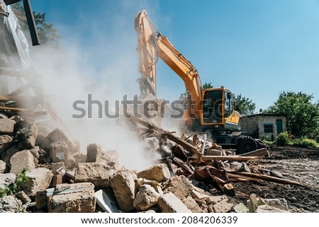Excavator destroy old house. Demolition of building