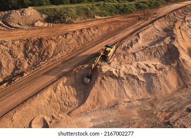 Excavator dig ground at construction site. Earthmover  on road construction. Heavy equipment and machinery. Backhoe on earthwork. Open pit development and sand extraction. Mining industry Reserves.
