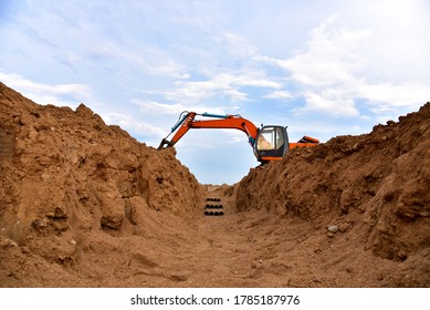 Excavator Dig The Trenches At A Construction Site. Trench For Laying External Sewer Pipes. Sewage Drainage System For A Multi-story Building. Civil Infrastructure Pipe, Water Lines And Sanitary Storm