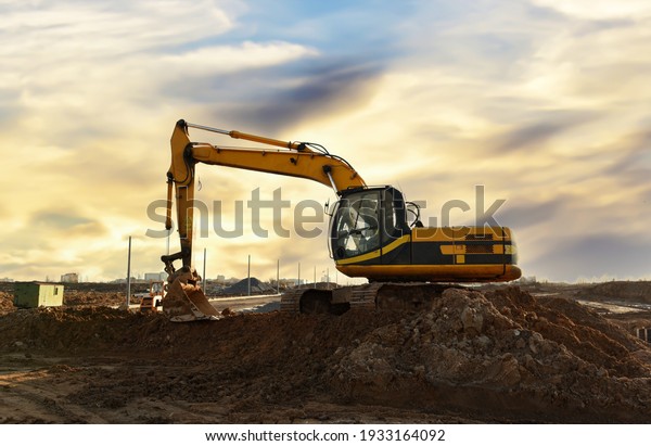 Excavator dig the trenches at\
a construction site. Trench for laying external sewer pipes. Sewage\
drainage system for a multi-story building. Digging the pit\
foundation.