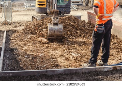 Excavator digging the ground for new driveway and footpath. New housing development - Shutterstock ID 2182924363