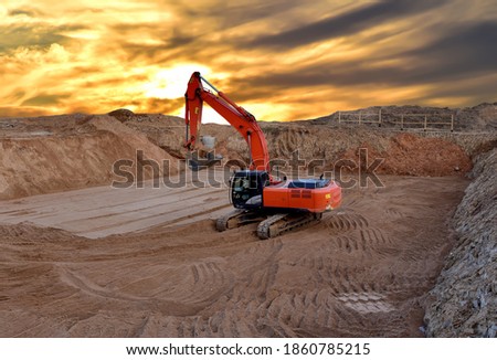 Excavator digging the pit foundation on sunset background. Earthwork in excavation and backfilling of soil is required for construction of trenche. Construction machinery for earthmoving
