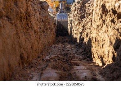 Excavator digging a trench ditch for a small house foundation